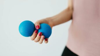 Faceless young woman with stress ball on white background