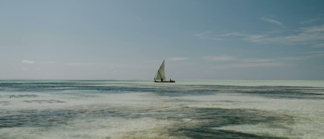 Lonely sailboat floating on foamy blue sea